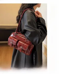 Detail view of burgundy underarm bag with glossy finish and double front buckle pockets