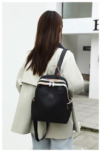 Detail of black waterproof nylon backpack with ethnic pattern straps on a model