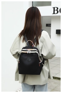 Detail of black oxford fabric backpack with colorful tribal webbing straps on the back