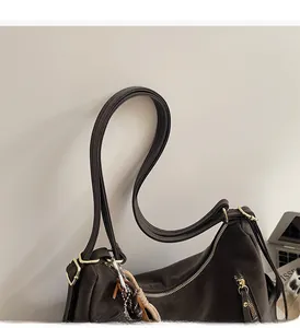 Detail of dark brown hobo bag featuring gold zipper hardware and side zipper accents