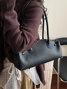 Minimalist black lychee leather baguette shoulder bag with stylish metal rivet details