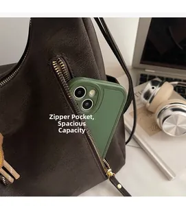 Close-up of vintage brown leather bag side zipper pocket holding a large smartphone
