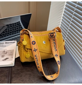 Detail of yellow nylon crossbody bag with stylish patterned wide jacquard shoulder strap