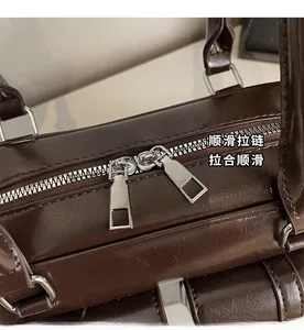 Close-up of smooth silver double zippers on dark brown shiny leather shoulder bag