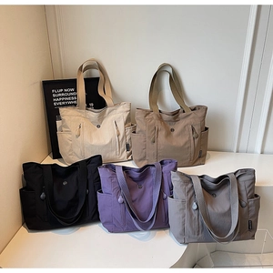 Detail view of large capacity tote bags in five colors with multiple functional pockets