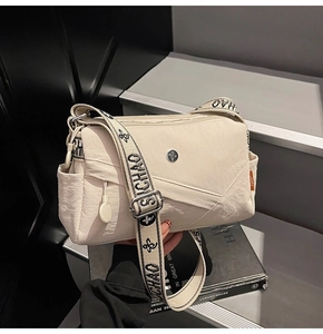 Detail of cream square crossbody bag with SICHAO brand wide woven adjustable shoulder strap