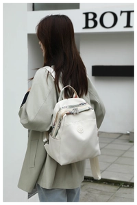 Outdoor shot of cream oxford backpack with ethnic embroidery on straps and side pocket