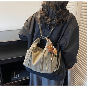 Détail d'un sac à dos en similicuir gris-vert avec fermetures éclair verticales