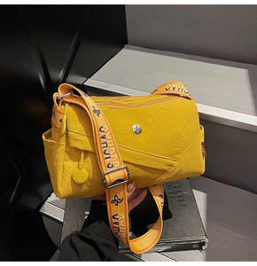 Detail of bright yellow nylon crossbody bag with wide jacquard strap and side pocket