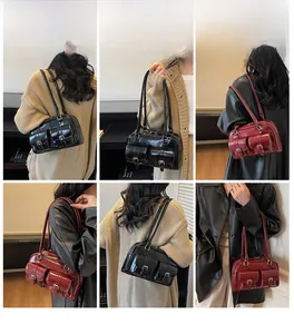 Retro multi-pocket Boston shoulder bag in black and burgundy leather displayed on model