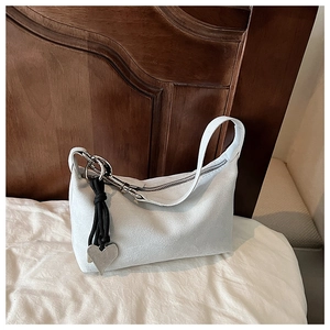 Détail du sac hobo en daim gris clair avec breloque cœur argentée et mousqueton métal