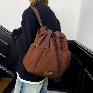 Detailed side view of brown drawstring backpack featuring nylon texture and side pockets
