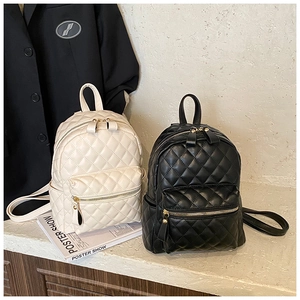 Detail of quilted leather backpacks in beige and black with premium gold zippers
