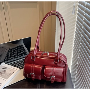 Detail of vintage burgundy shoulder bag with dual zipper and double front buckle pockets