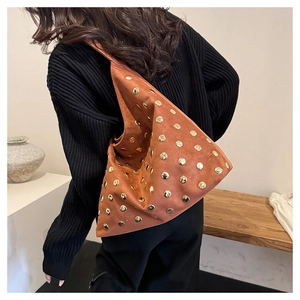 Detailed view of vintage brown suede tote bag with golden metal rivets on shoulder strap