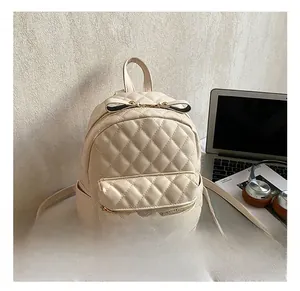 Détail d'un sac à dos matelassé crème avec fermeture éclair à nœud élégant