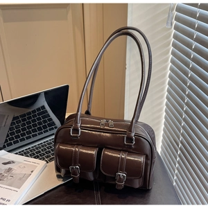Detail of dark brown vintage Boston bag with glossy finish and double front buckle pockets