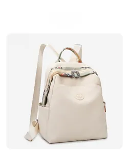 Detail view of cream oxford backpack with ethnic woven handle and circular brand logo
