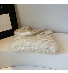 Detail view of cream crochet tote bag featuring mohair texture and front pockets