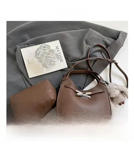 Brown lychee leather bucket bag set with silver lock, long strap and plush rabbit charm