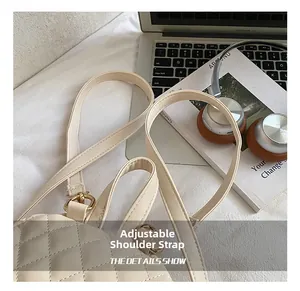 Détail de la bandoulière réglable et des garnitures dorées du sac à dos beige