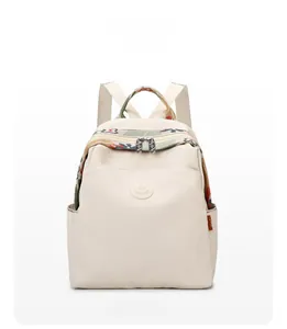 Front view of beige waterproof nylon backpack featuring vintage bohemian patterned straps