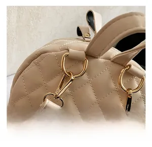 Détail des crochets dorés et coutures sur un sac en cuir beige avec matelassage