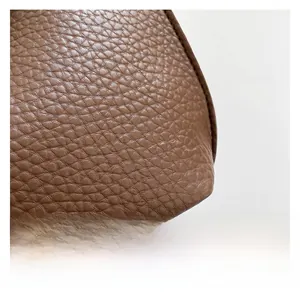 Close-up of premium brown litchi grain leather texture on the fashion bucket bag