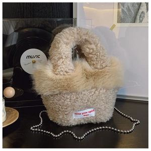 Detail of beige teddy fleece handbag with plush faux fur trim and silver bead chain strap