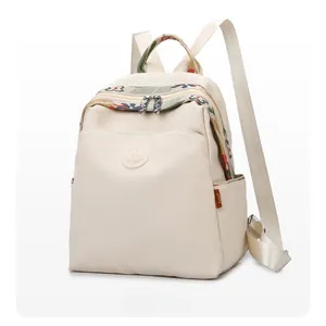 Detail view of off-white oxford backpack with ethnic woven handle and dual zippers