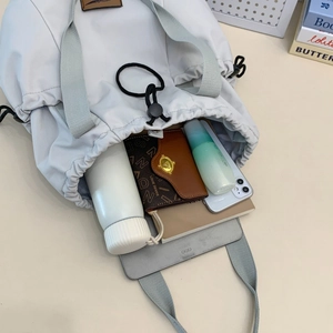 Detail of spacious nylon drawstring bag showing interior storage for tablets and bottles