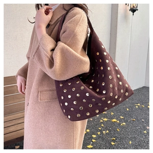 Detail view of large dark brown suede tote bag with all-over gold rivet studs