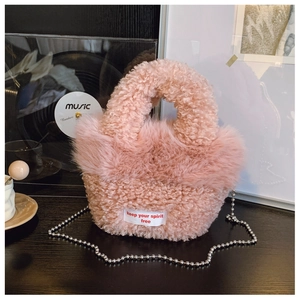 Detail of pink plush crossbody bag with furry texture and stylish silver bead chain