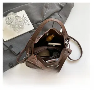 Interior view of brown bucket bag showing spacious capacity with a zippered inner pouch