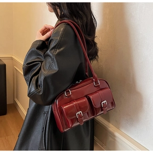 Detailed side view of deep red vintage Boston bag with silver buckles and glossy leather texture
