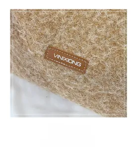 Close-up of the plush wool-like fabric texture and the leather brand logo on the tote bag