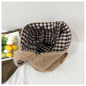 Detailed interior of brown knit tote bag showing retro plaid lining and inner pocket