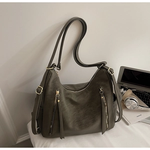 Gros plan du sac à dos vert olive montrant la texture du similicuir et les zips dorés