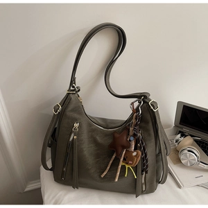 Détail du sac fourre-tout vert olive avec fermetures éclair et pendentif ours mignon