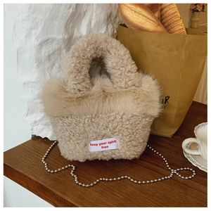 Detail of beige faux fur handbag with silver bead chain and spirit free slogan tag