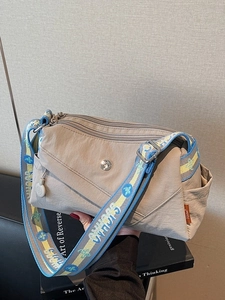 Khaki nylon crossbody bag with multi-zipper pockets and floral embroidered wide strap
