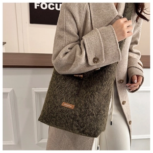Detail of green faux fur tote bag showing plush texture and drawstring closure with logo patch