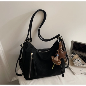 Détails du sac multifonctionnel noir avec zips dorés et breloques ours et étoile