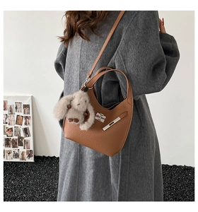 Brown lychee leather hobo bag with metal buckle and cute plush bunny charm on shoulder