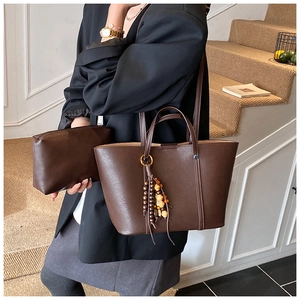 Dettaglio del set borsa tote in pelle marrone scuro con nappa di perline vintage