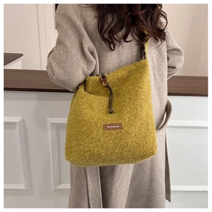 Detail view of mustard yellow plush tote bag showing soft faux fur and brown drawstring