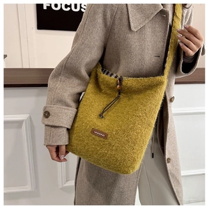 Close-up of yellow fuzzy tote bag with leather logo patch and black-and-white plaid lining