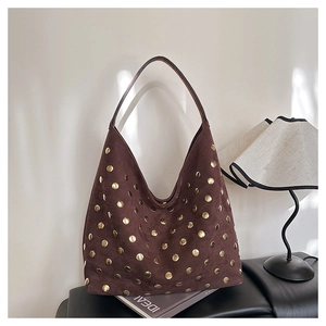 Detail of vintage brown suede tote bag featuring polished gold metal rivet studs