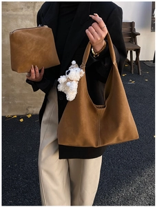 Brown suede tote bag set with plush bear charm and matching pouch shown in street style