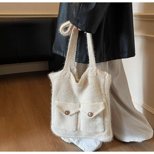 Détail d'un sac cabas en maille crème avec texture mohair et grandes poches avant